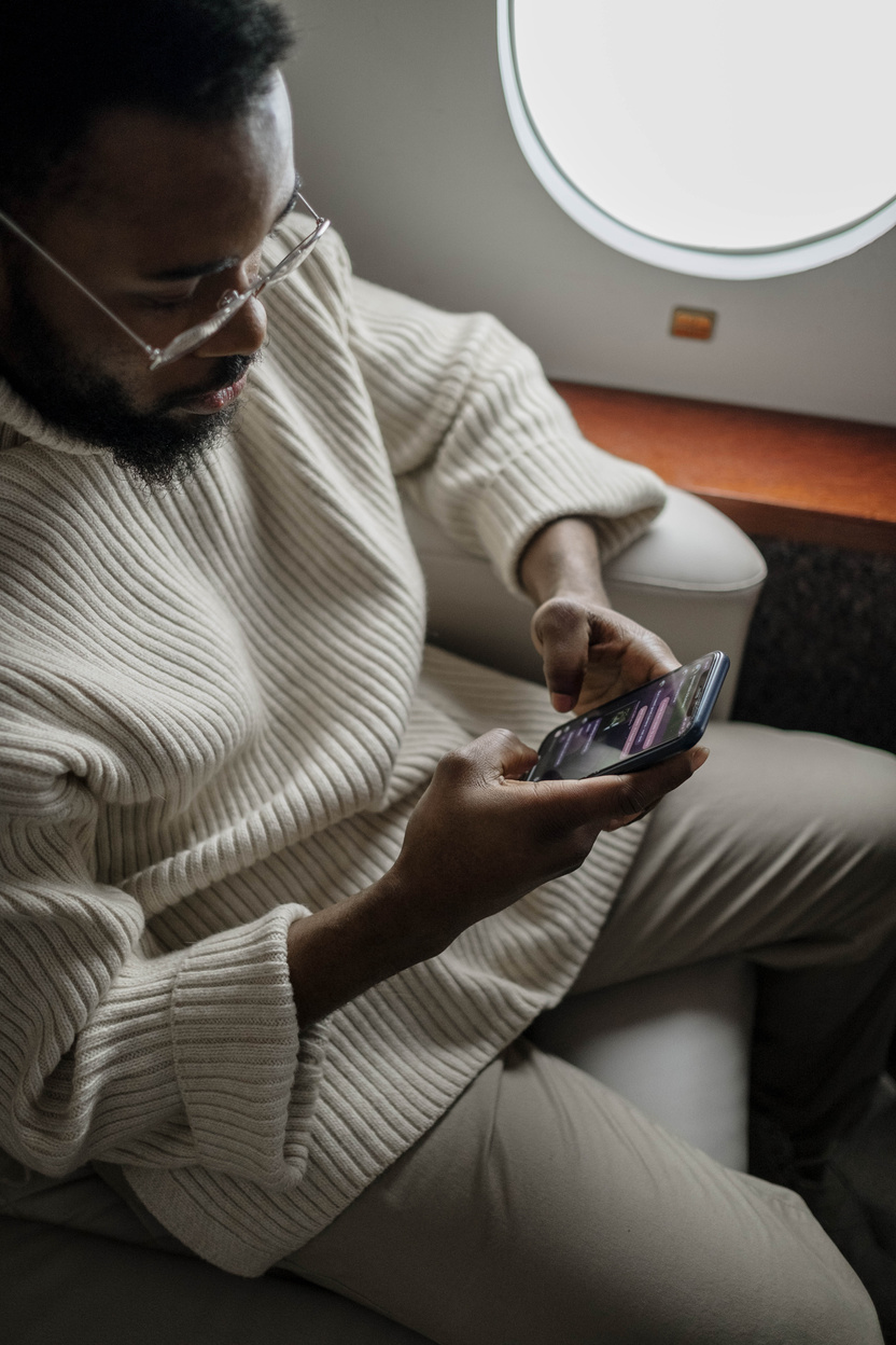 A Man Texting Inside an Airplane