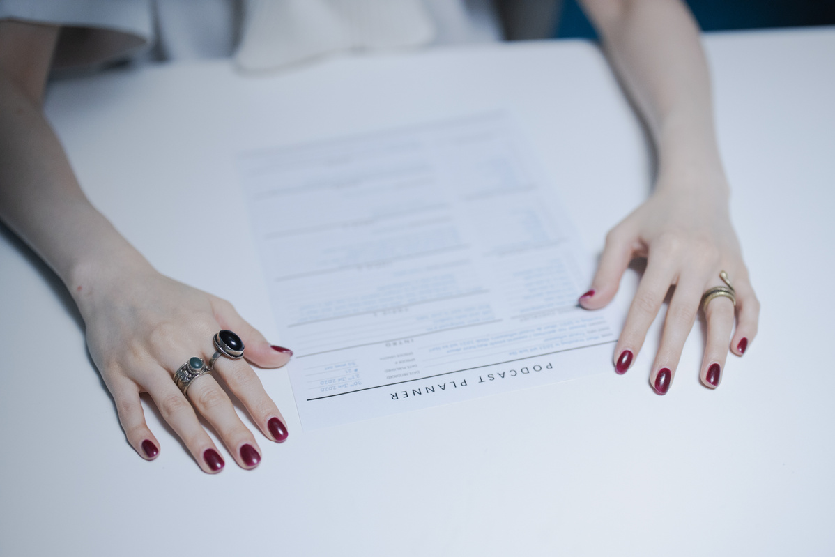 Hands Touching the Document on a White Surface